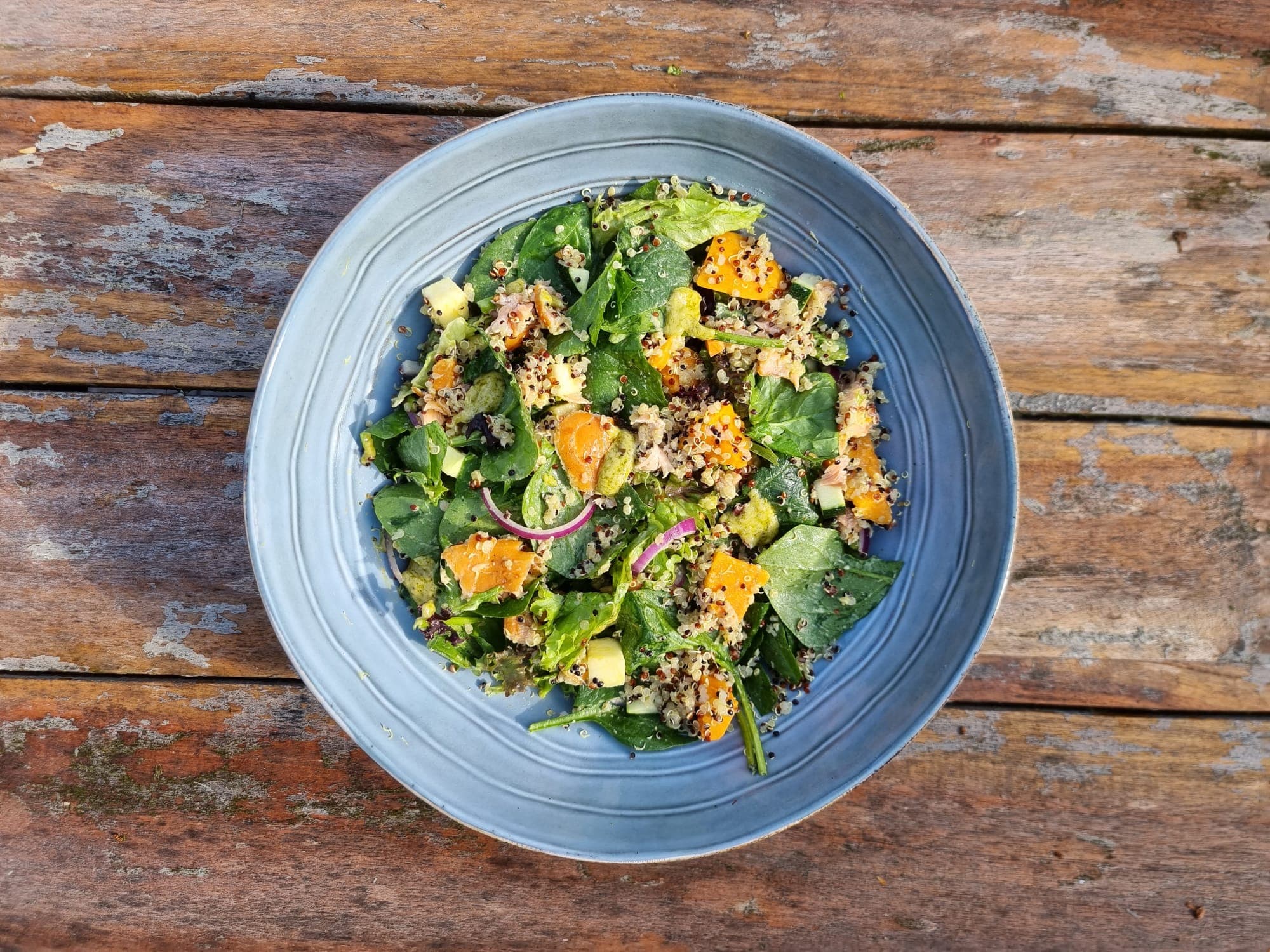Quinoa salade met warm gerookte zalm en pesto dressing