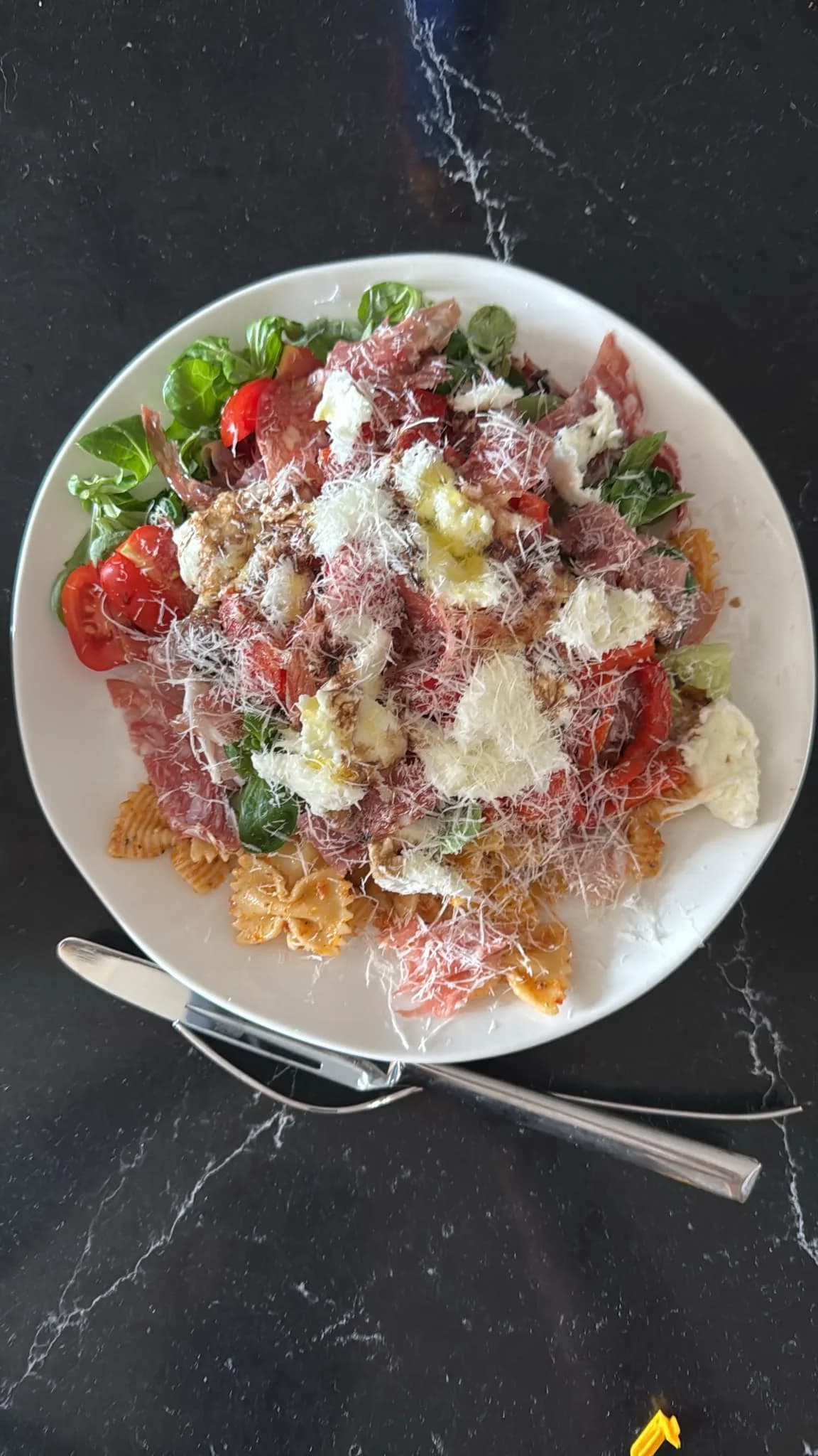 Italiaanse pastasalade met salami, mozzarella en rode pesto